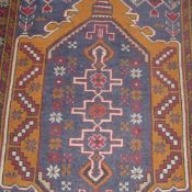 A hand knotted Persian prayer rug the blue ground with central motif in triple border