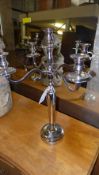 A pair of plated five light candelabra on round base