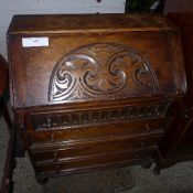 A carved oak fall front bureau with fitt