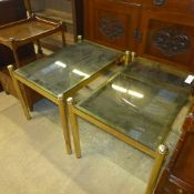 A pair of modern smoky glass top low tables raised on brass cylindrical support