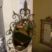 A wrought iron wall mirror the oval beve
