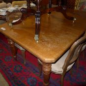 A Victorian oak extending dining table with two extra leaves on fluted supports