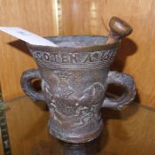 A bronze mortar and pestle with coat of
