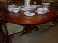A mid C20th Danish rosewood dining table, the circular top on pedestal base extending to take two