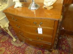 A Georgian style mahogany serpentine chest having four graduated drawers on bracket feet