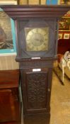 An oak longcase clock with brass dial in carved case