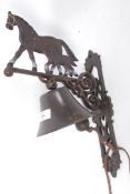 A 20th century cast iron wall hanging bell in the form of a horse.