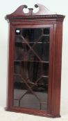 A 19th century Georgian solid mahogany hanging corner display cabinet having shelved interior with