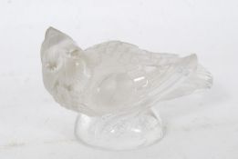 A 20th century moulded glass car mascot in the form of a bird raised on plinth