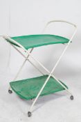 A 1970's tubular metal and green plastic two tier serving trolley raised on the original castors.