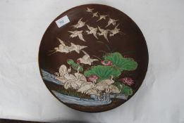 A large 20th century Japanese cloisonne wall plate decorated in relief of storks and lily pads