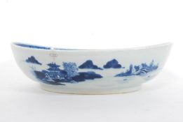 A 19th century Chinese export porcelain oval shaped blue and white bowl being decorated with a