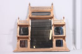 A large Victorian gilt overmantel mirror having fret pierced detailing to the top with finials being