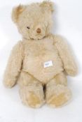 An early 20th century straw stuffed large mohair teddy bear