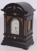 A large ebonised 18th century style musical bracket clock with decorative face, roman numerals being