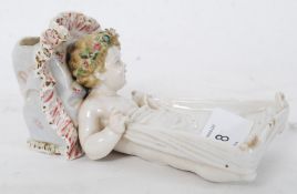 A 19th century miniature bisque continental vase in the form of a baby in bed. Great detailing all