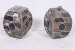 A pair of 1920's Arts & Crafts revival oak lined stained glass lanterns. Of square bulbous form