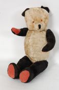 A mid century straw filled Panda teddy bear with growler