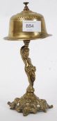 A vintage brass bell mounted atop a brass figure of a boy.