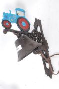 A 20th century cast iron wall hanging bell with farm tractor to top, hand painted