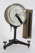 A 20th century Torsion balance scale having bevelled glass with brass surround raised on