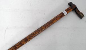A good tribal walking stick with carved inlaid twin wood detailing having bone teeth alligator