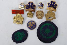 A collection of girl guide enamel badges dating to the 20th century along with patches ( see