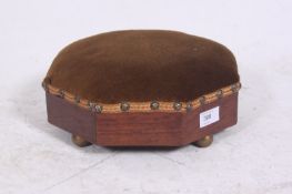 A Georgian mahogany octagonal footstool being raised on brass feet with upholstered centre. 12cms