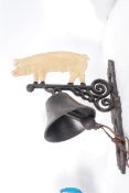 A 20th century cast iron wall hanging bell with formed pig to top, hand painted