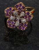 A 9ct gold diamond and amethyst flower head ring set on simple form hoop being hallmarked to the