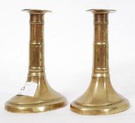 A pair of Georgian pusher brass candlestick holders, fluted design with ribbing to central shaft