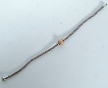 A silver bangle with a CZ cluster ball