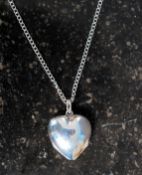 A silver heart shaped locket on white me
