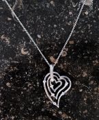 A silver necklace with a graduated heart