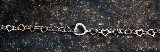 A silver heart shaped bracelet set with