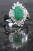 A silver CZ and faux emerald ring