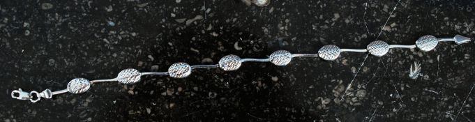 A silver bracelet with oval drop link ch