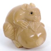 A carved mouse holding a nut