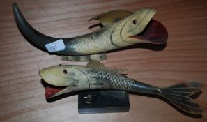 Two wooden fish on plinths