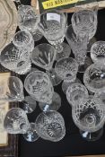 A large collection of crystal cut glass wine glasses