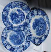 A blue and white large dish with two plates with cottages depicted