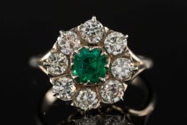 An emerald and diamond mounted circular