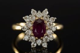 An 18ct gold, ruby and diamond oval clus