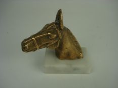 A brass horse head mascot on later marbl