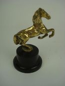 A brass horse mascot:, unsigned, on blac