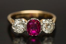 A gold, ruby and diamond three-stone rin