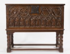 A carved oak coffer on stand in the Goth