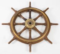 A ship's oak and brass eight spoke wheel,