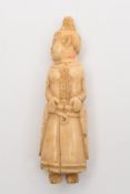 A marine ivory carved figure of a Polynesian woman:, in traditional costume, 10cm high.