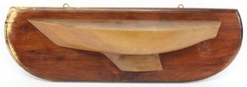 A half block model of a yacht:, with shaped keel, mounted on a mahogany plinth, 84cm long.